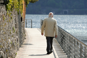 old man walking on a boardwalk