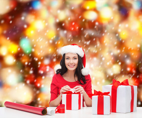 woman in santa helper hat with many gift boxes