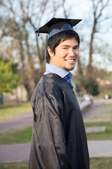 Happy Man In Graduation Gown On University Campus