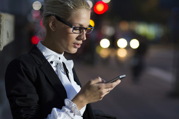 Girl with smartphone walking on city