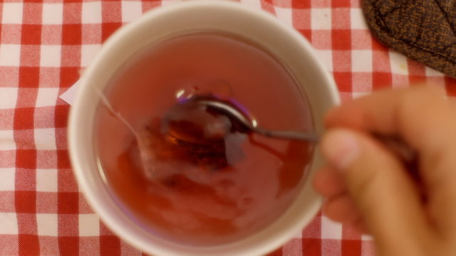 Tea cup from above teaspoon full of honey