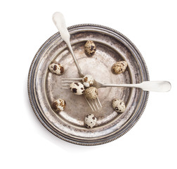 Clock made of quail eggs on silver plate with forks