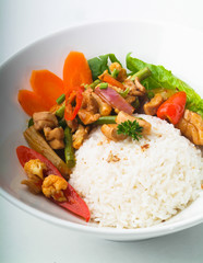 Chicken with rice and vegetables in background