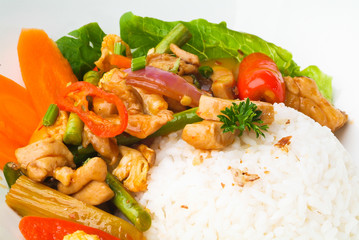 Chicken with rice and vegetables in background
