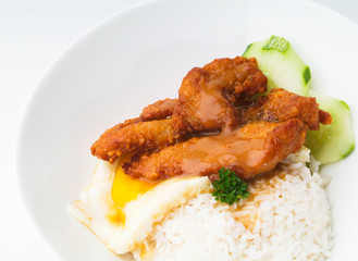 Chicken with rice and vegetables in background