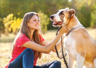 Portrait of a woman and central Asian shepherd in park outdoors