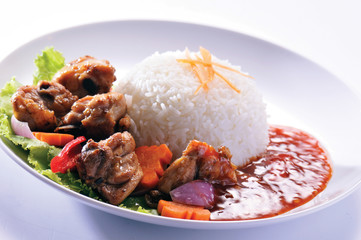 Chicken with rice and vegetables in background
