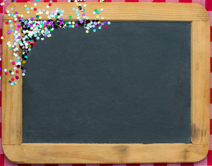 Christmas frame of confetti on blackboard
