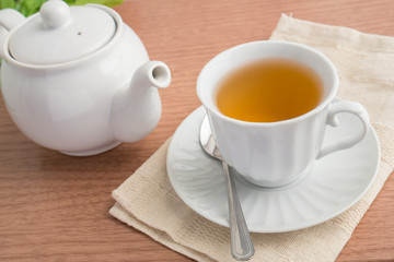 Fototapeta na wymiar A cup of green tea and a teapot
