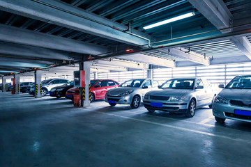 Parking garage, interior with a few parked cars.