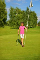 Golf, girl golfer with a stick and a flag on the green