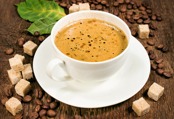 coffee on a wooden background with beans and cane sugar