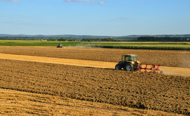 Fototapeta premium Two tractors working on a field
