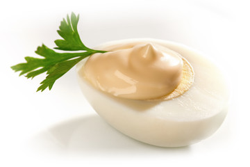 Hard boiled Egg on white background with potherb ans mayonnaise