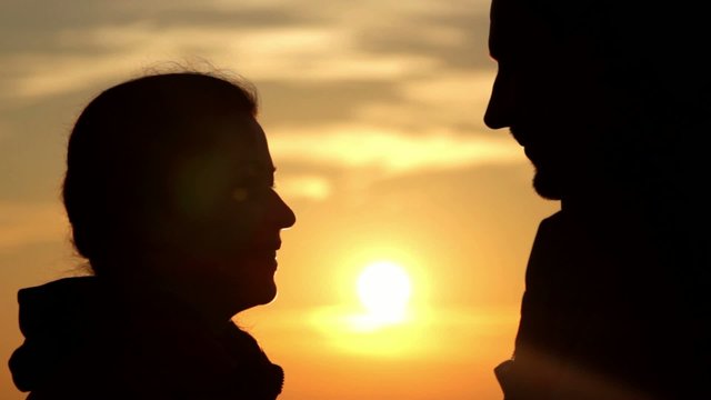 boy and girl kissing at sunrise(close-up)