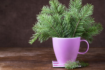 Fir-tree twigs in a mug on old wooden table
