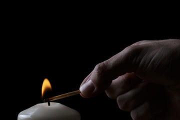 adult man hand set fire a candle