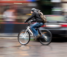 Fototapeta na wymiar Człowiek na rowerze w mieście. Celowe rozmycie ruchu
