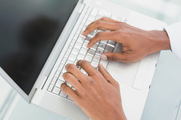 Hands using laptop at medical office