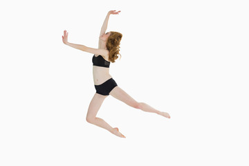 Fototapeta na wymiar Full length side view of a sporty woman jumping