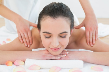 Beautiful woman enjoying shoulder massage at beauty spa