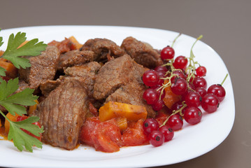 Meat stew with vegetables and red currants