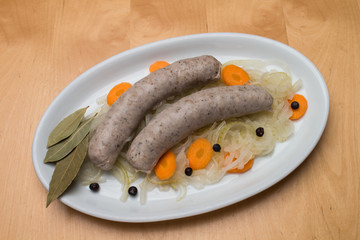 Sauere Bratwurst auf ovalem Teller mit Karotten