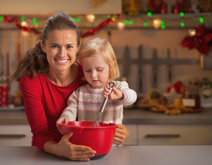 Baby helping mother make christmas cookies