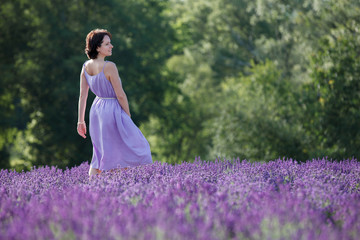 Fototapeta na wymiar Young woman relaxing in lavender field