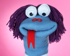 Cute sock puppet on pink background