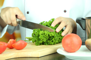 Cook hands cutting parsley