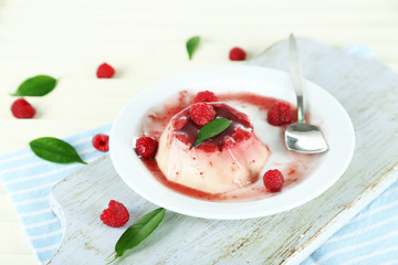 Panna Cotta with raspberry sauce, on wooden background