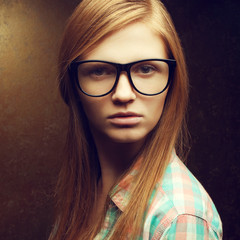 Young beautiful red-haired girl wearing trendy glasses