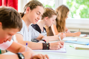 Schüler schreiben Klassenarbeit oder Test in Schule