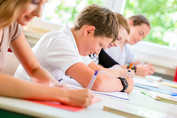 Schüler schreiben Klassenarbeit oder Test in Schule