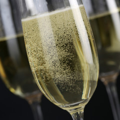 Perlender Sekt mit schwarzem Hintergrund