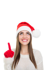 Happy young woman with Santa Claus hat pointing and looking up