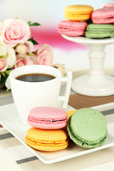 Coffee and macaroons on table on light background
