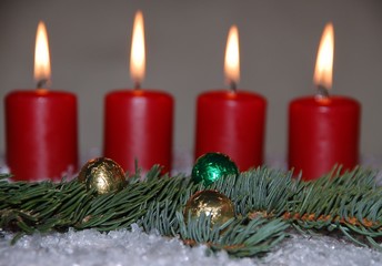 Weihnachtskerzen mit Kugeln und Tannenzweig