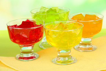 Tasty jelly cubes in bowls on table on light background