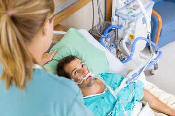 Patient Looking At Nurse As She Adjusts His Pillow