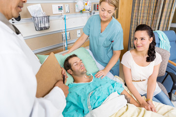 Woman Looking At Doctor While Holding Man's Hand