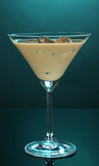 Baileys liqueur in glass on blue background