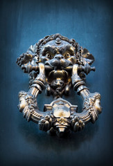 Fototapeta na wymiar Antique knocker on a wooden door, Rome