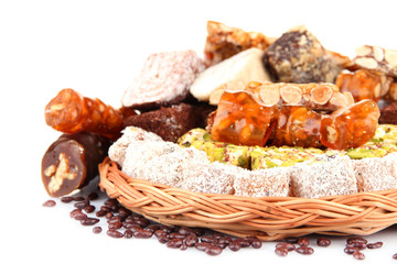 Tasty oriental sweets on wicker tray, isolated on white