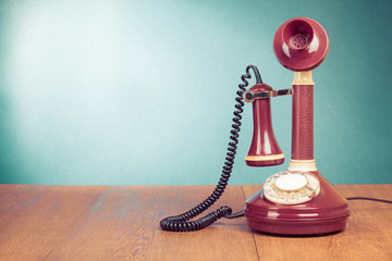 Old retro telephone on wood table front mint green background