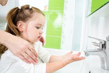 kid washing hands with adult