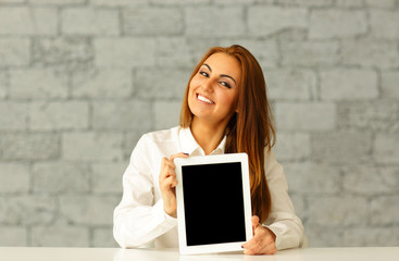 Young happy businesswoman showing tablet computer display