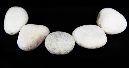 White zen stone over black background