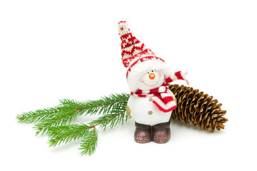 toy snowman and fir-cone on a branch on a white background